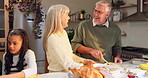 Elderly, couple and prepare food for thanksgiving in kitchen with family, happiness and feast for festive celebration. Senior people, child and together in home with turkey, laughter and conversation