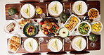 Above, table and food for thanksgiving dinner, celebration and reunion with meal. Wine bottle, glasses and turkey on dining table for love, support and unity with vegetables for gathering or event