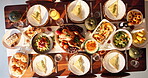 Above, thanksgiving and food for dinner on table with plate layout, vegetables and chicken roast for celebration. Social event, dining room setup and nutrition with wine bottle or feast for tradition