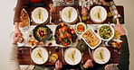 Above, family and holding hands on dinner for thanksgiving with praying, grace and appreciation. People, food and table at home to feast with unity, support and care on gathering for love and peace