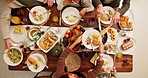 Dining table, food and hands of family at thanksgiving dinner with chicken, vegetables and juice. Meal, gathering and people at social festive event celebration for dinner, lunch or supper from above