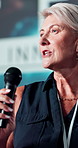 Conference, speaker and woman with microphone at stage for economy innovation, speech or event. Government, summit and political leader with discussion for development, solution or global policy plan