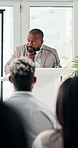 Black man, nervous and podium with audience for speech, presentation or meeting at seminar. African speaker, businessman or spokesperson with anxiety, stress or sweat in crowd for group ceremony