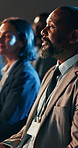 Conference, businessman and hand with question in audience for training, information and inquiry. Crowd, discussion and people with participation at seminar for presentation, learning and feedback