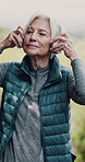 Senior woman, headphones and fitness for retirement, wellness and cardio health outdoor while running. Elderly person, technology and music for streaming, exercise and podcast in nature as vertical