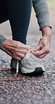 Hiking, senior hands and tie shoes on road to start running, workout or training. Mature woman, wellness and tying sneaker laces or footwear to prepare or ready for exercising or cardio outdoors