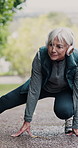 Runner, outdoor and senior woman warm up on road for fitness, health and hiking in retirement. Stretching, exercise and mature person in nature for workout, cardio and training with music or podcast