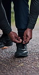 Hiking, mature hands and tie shoes on road to start running, workout or training. Senior man, wellness and tying sneaker laces or footwear to prepare or ready for exercising or cardio outdoors