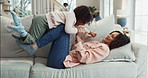 Flying, playing and mom with child on sofa for bonding, love and playful relationship in living room. Family home, childhood and mother with young girl for laughing, fun and relax on weekend together