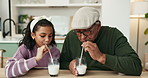 Girl, grandfather and glass for milk in kitchen for game, smile or bonding with connection in home. Senior man, child and drink for dairy, nutrition or diet for contest, care or love in family house