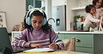 Girl, child and writing with headphones for homework, education and notes for online course. Kid, laptop and studying with streaming, video and listen in virtual class at family house in Brazil