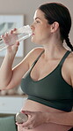 Woman, pregnant and drinking water in home with smile, fitness and hydration in yoga. Bottle, future mom and thirsty in pilates for healthy body, nutrition and wellness with liquid for prenatal care