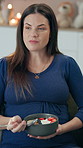 Thinking, pregnant woman and relax on sofa for eating fruit salad, healthy snack and balanced diet for nutrition. Mother to be, belly and living room in house with food for prenatal development.