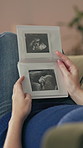 Pregnant woman, hands and photo album with ultrasound for scan, memory or pictures of baby development. Closeup of female person, maternity or pregnancy with exam for week, month or growth at home