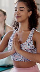 Girl, happy and calm with meditation in yoga class for mindfulness, mental health and breathing for peace. Female people, praying hands and eyes closed for spiritual healing exercise and wellness.