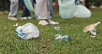 Trash, cleaning and volunteers in outdoor park for community service, waste or garbage pollution. Charity, bags and ngo employees tidying grass of dirt for eco friendly project in environment.