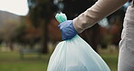 Park, person and hand with garbage bag in nature for environment, cleaning and community service. Outreach, volunteer and glove with plastic in forest for NGO project, recycling and waste management