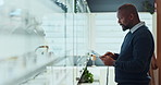 Man, optometry and tablet for eye care stock, quality control and consultation as optometrist. Male person, tech and spectacles on display in clinic or ophthalmology center for size, frame and lens