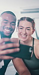 Interracial couple, fitness and selfie with achievement for training, exercise or workout together at gym. Happy man, woman and smile in celebration for picture, moment or photography at health club