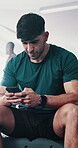 Man, gym and fitness with texting on smartphone on internet  for exercise, training and workout video. Male person, body builder and happy on social media with tips for healthcare and wellness