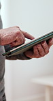 Senior, hands and scrolling with tablet for news, social media or online browsing at home. Closeup of elderly person indoors with technology for app navigation, information or connectivity at house