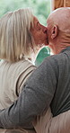 Senior couple, back and kiss with hug by door for love, care or support together in retirement home. Elderly man and woman with embrace, intimacy or romance by window for morning affection at house