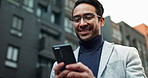 Business, Asian man and smile outdoor with texting on smartphone for social media in New York. Male person, from below and happy with browsing internet for entertainment, networking and communication