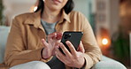 Hands, phone and texting on sofa in home with contact, scroll or reading notification in living room. Person, smartphone and click with mobile app for post, social network and relax on couch in house