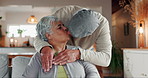 Old couple, kiss and hug in home for support, commitment and love for comfort in living room. Elderly people, couch embrace and romance in retirement, security and bonding for trust in marriage