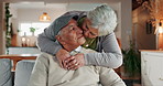 Senior couple, face and kiss in home for support, commitment and love for comfort in lounge. Elderly people, couch embrace and romance in retirement portrait, Mexico and bonding for trust in marriage