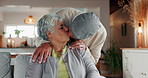 Old couple, kiss and love in home for support, connection and hug for comfort in lounge. Elderly people, couch embrace and romance or loyalty in retirement, security and bonding for trust in marriage