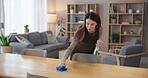 Cleaner, woman and wipe table in house with detergent for cleaning service, bacteria or household maintenance. Housekeeping, person and liquid chemical disinfectant for dirty surface and dust in home