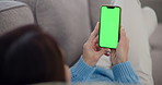 Woman, hands and phone with green screen on sofa for mobile advertising, app or browsing at home. Closeup, female person or smartphone with chromakey display for marketing on mockup space at house