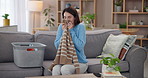 Laundry, happy and housewife smell clothes with smile for housekeeping, spring cleaning and washing. Woman, living room and aroma with basket of clothing, fresh linen or fabric scent for home comfort