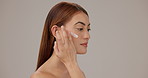 Moisturizer, skincare and woman in studio with natural, hydration and face elasticity. Beauty, facial cream and person with dermatology routine for smooth texture with glow by gray background.