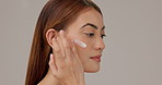 Face cream, skincare and woman in studio with natural, hydration and facial elasticity. Beauty, moisturizer and female person with dermatology routine for smooth texture with glow by gray background.