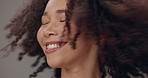 Aesthetic, haircare and woman with satisfaction, natural afro or confidence on grey studio background. Face, happy model and treatment for cosmetic, salon grooming and keratin for playful beauty glow