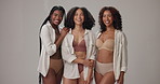 Underwear, diversity and happy women in studio for wellness, beauty and body positivity. Lingerie, group and portrait of people hug in bra with confidence, self love and inclusion on gray background