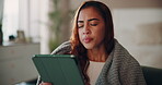 Woman, home and sleepy on tablet with blanket on couch for browsing social media and internet.Female person, house and exhausted or tired in bedroom on sofa for online communication and networking