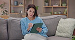 Mature woman, home and scroll with tablet for online gaming, entertainment or relax on weekend. Female person, happy and rest on technology on mobile app, streaming service and social network on sofa