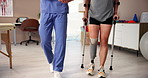 Physiotherapist, crutches and woman with prosthetic leg for walking, rehabilitation or help. Amputee patient, nurse and person with disability in clinic for medical, healthcare or talking for support