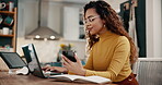 Woman, phone and typing on laptop with notebook in home for article research, freelance blog post and web search. Remote work, entrepreneur and copywriter with tech at dining table for multitasking