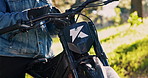 Hands, bike and put on gloves closeup outdoor for safety, protection and travel equipment. Rider, motorcycle and person with gear to prepare for sport, adventure and start journey on transportation