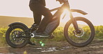 Ebike, energy and sunset with person in nature for sustainability, cycling and travel. Peace, environment and speed with ride on dirt path trail for challenge, carbon footprint and transportation