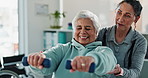 Happy woman, physiotherapist and senior with dumbbells for exercise or therapeutic technique at clinic. Female person, therapist and elderly patient with weightlifting for recovery or therapy session