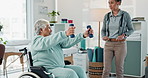 Happy woman, physiotherapist and patient with dumbbells on wheelchair for exercise or physical therapy at clinic. Therapist, health professional and person with a disability for fitness or wellness