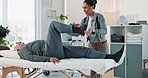 Woman, physiotherapist and stretching leg with patient for physical therapy, muscle exercise or recovery at clinic. Female person, therapist and elderly man with knee injury, joint pain or ache