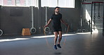 Exercise, cardio and jump rope with man in gym for training, muscle connection and workout. Health, strong and sports athlete with male person and skipping for energy, fitness and strength movement