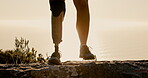 Legs, fitness and prosthetic limb for hiking on mountain for exercise, workout and health with sunset. Closeup, training and person with a disability outdoor for adventure, hobby and rehabilitation