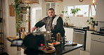 Talking, live streaming and man in kitchen for cooking dinner, cuisine and tutorial in home. Culinary influencer, content creator and person with food, recipe and ingredients for social media vlog